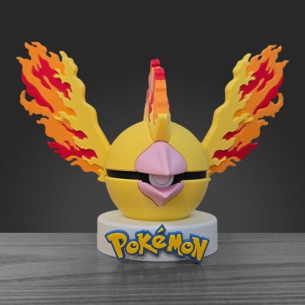 Pokéball Sulfura face : corps jaune doré, long bec effilé et crête enflammée sur socle blanc.